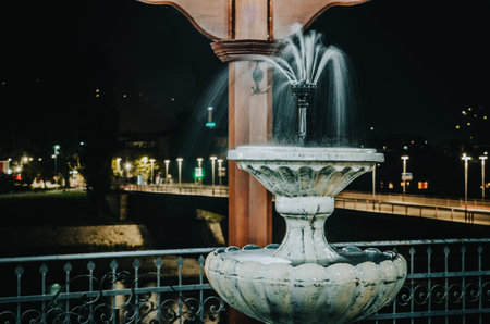 A fountain by the river in a park at nightの写真素材