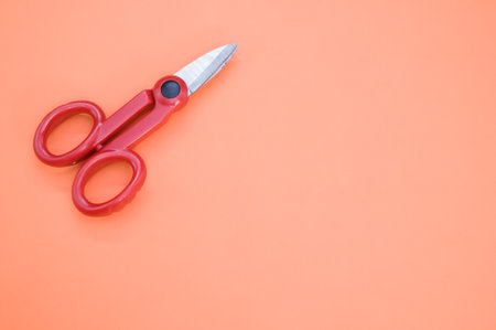 A closeup shot of red scissors on a colorful backgroundの写真素材