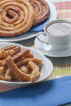 A vertical shot of delicious homemade churros with a cup of coffeeの写真素材