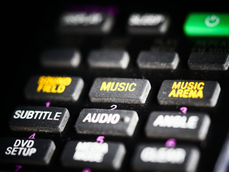 A selective focus shot of black remote control rubber buttons against a dark background
