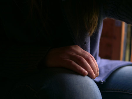 Hand resting on knee on isolated on blue backgroundの写真素材