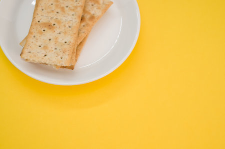 A plate with salty crackers on a yellow surface