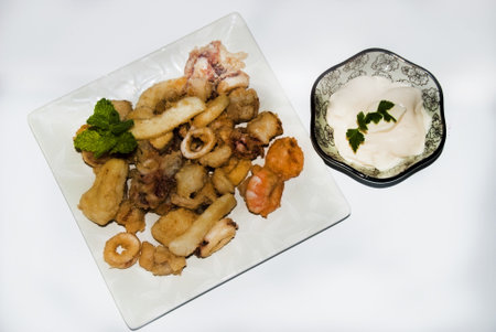 A plate of fish fry with a bowl of mayonnaise on white backgroundの写真素材