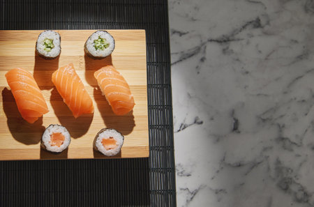 A top view of delicious sushi rolls and salmon sushi on a wooden boardの写真素材
