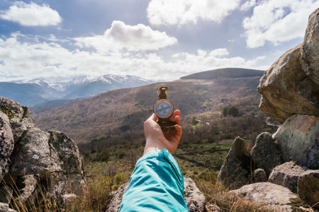 An arm of a female hiker with a compass against a beautiful landscapeの写真素材