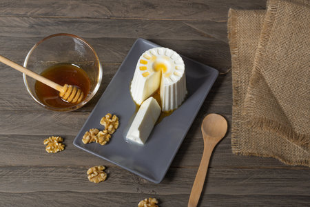 fresh cheese with honey and walnuts with different containers and backgroundsの写真素材