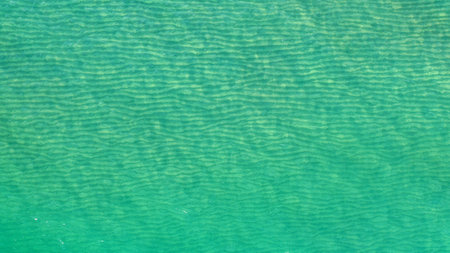 An aerial view of the turquoise sea with wavy pattern - cool as wallpaper or background