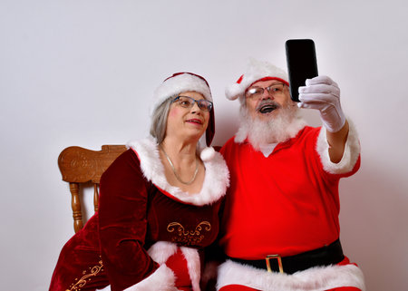 Lovely Mr and Mrs Santa Claus taking a selfieの写真素材