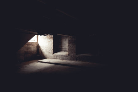 The light shining through a window into the dark basementの写真素材