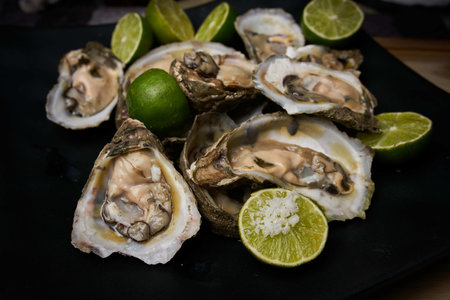 A closeup shot of fresh oysters with lime slicesの写真素材