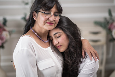 Mexican mother and daughter hugging on the mother's dayの写真素材