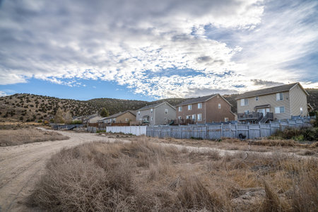 A countryside dirt road next to modern residential buildings