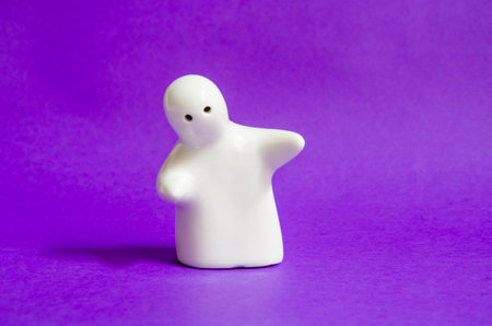 A white ghost figurine on a purple backgroundの写真素材