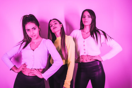 A portrait of young beautiful Caucasian women partying in a nightclub with pink neon lightsの写真素材