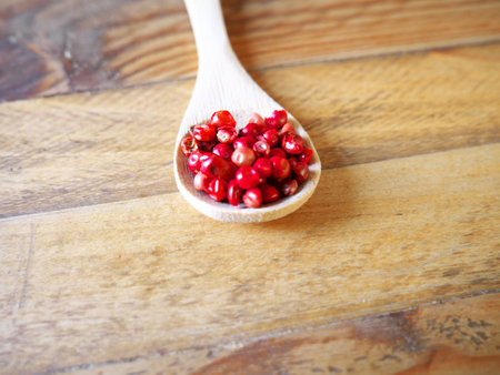 A pink peppercorns in a wooden spoonの写真素材