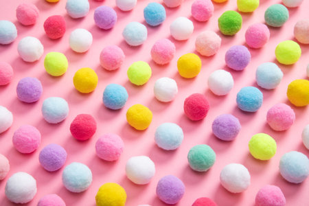 The colorful soft pom pom balls on pink backgroundの写真素材
