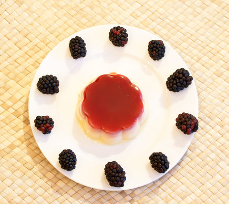 An overhead shot of pudding served with fresh bramblesの写真素材
