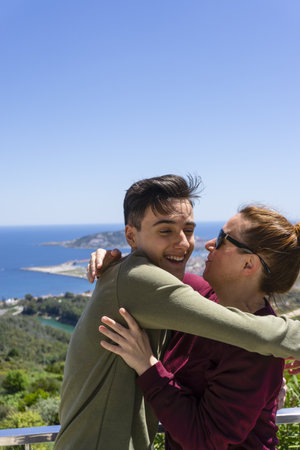 A Caucasian young guy hugging his mom on an observation deckの写真素材
