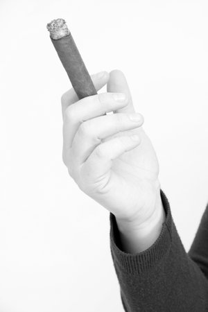 A closeup grayscale shot of a hand holding a cigarの写真素材