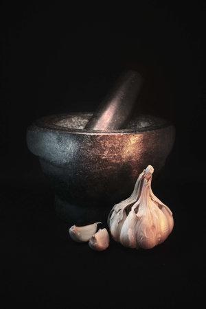 A vertical shot of garlic near the manual old squeezerの写真素材