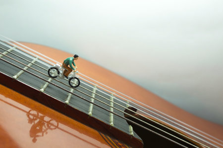 A closeup shot of a small figure of a bicyclist on a classical guitarの写真素材