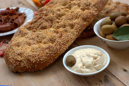 sesame bread, with traditional Mediterranean delicacies. taramas, olives, beans, squid