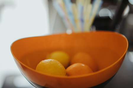A selective focus shot of lemons and oranges in a bowlの写真素材