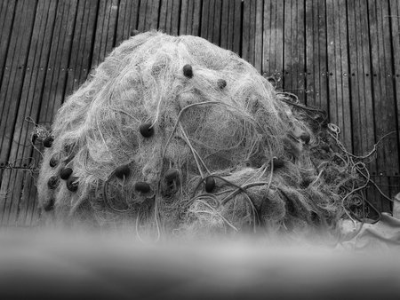 trawl fishing net, piled up on a quay in the harborの写真素材
