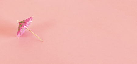A high angle shot of a pattern with pink cocktail sun umbrellaの写真素材
