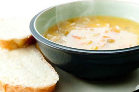 Hot chicken noodle soup and bread slices with cream cheeseの写真素材