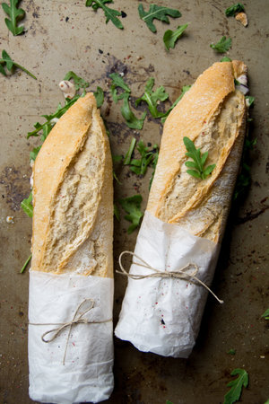 A vertical shot of French baguettes with arugula leavesの写真素材