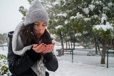 A playful young caucasian woman with brown hair in a winter parの写真素材