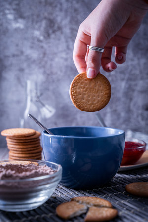 A vertical shot of a hand holding a freshly bak Maria cookie (galleta Maria)の写真素材