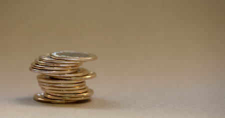A closeup shot of stacked coins on a tableの写真素材