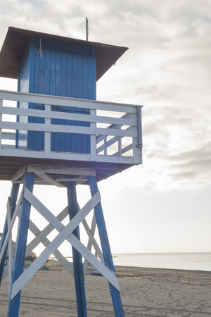 A vertical shot of a blue lifeguard house on the shore in Malaga, Andalucia Spainの写真素材