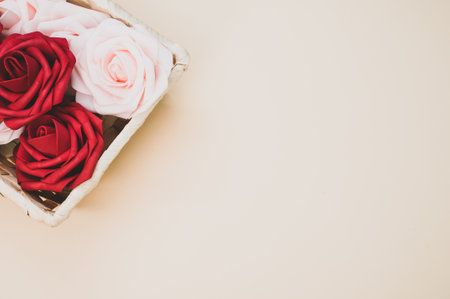 Beautiful red and white roses in a box isolated on a beige backgroundの写真素材