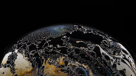 A macro shot of a soap bubble isolated on a black background - perfect for wallpapersの写真素材