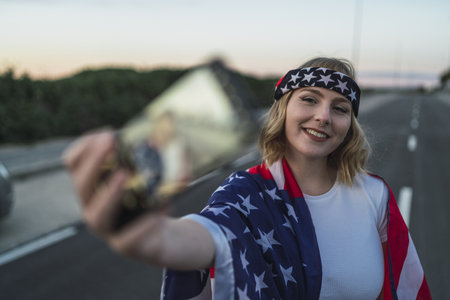 A soft focus of the phone of a Caucasian woman taking a selfie in the middle of the roadの写真素材