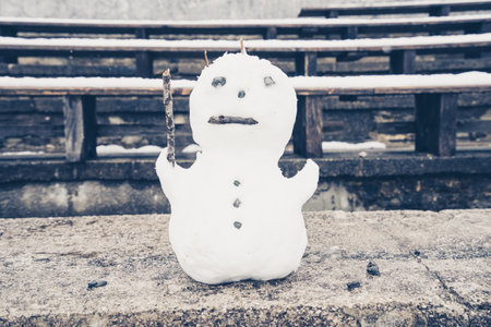 A close-up shot of a white snowman with the stick-on stone ground in Tyrol, Austriaの写真素材