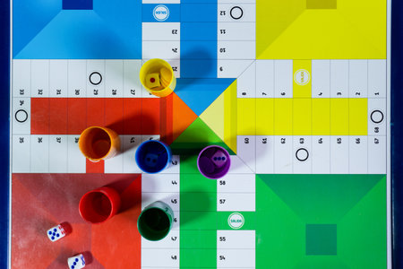 A top view of colorful play figures with dice on a game boardの写真素材