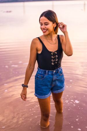 A young female in a black swimsuit and shorts at the pink lagoon of Torrevieja, Alicante, Spainの写真素材