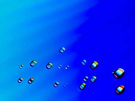 Close-up of water drops on a coloured surface in blue