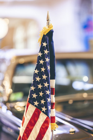 The US flag on an old vintage shiny carの写真素材