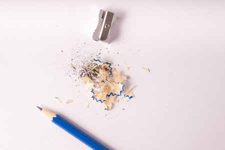 A top view of a blue pencil with metal sharpener and shavings isolated on a white backgroundの写真素材