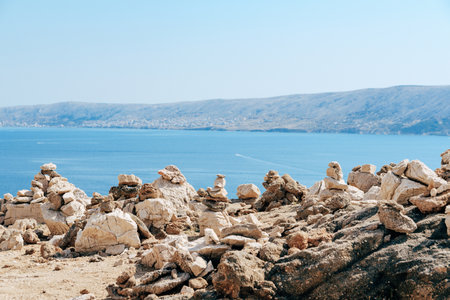 A scenic view of stone cairns on a blue sky background
