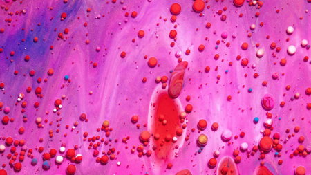 An abstract background of bobbly and mixed red and pink oily paints