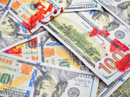 A closeup shot of dollar bills with red blood spots on themの写真素材