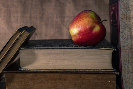 A closeup of a fresh ripe red apple on a closed bookの写真素材