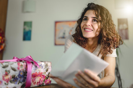 A Caucasian woman receiving a gift box with a greeting cardの写真素材