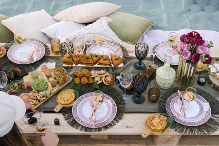 A top view of a picnic table full of appetizing foods, wonderful evening on the sunny beach